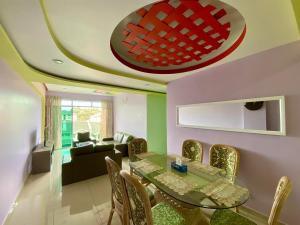 a dining room with a glass table and chairs at SK Holiday Apartment in Tanah Rata