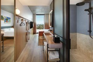 a bathroom with a sink and a shower and a bedroom at Moxy Sydney Airport in Sydney +96 photos