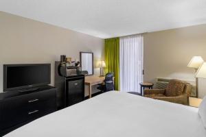 a hotel room with a bed and a flat screen tv at Quality Inn Tyler - Lindale in Tyler