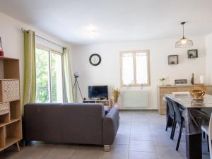 a living room with a couch and a table at **Gîte cosy avec terrasses et jardin à 7 km de Montignac, tout équipé, idéal pour explorer la Dordogne** - FR-1-616-202 in Auriac-du-Périgord