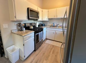 a kitchen with white cabinets and a stove top oven at Downtown Coastal Trail 2 BDR 1 BTH Sleeps 2-6 in Anchorage +11 photos