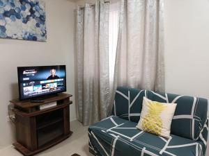 a living room with a couch and a television at Spacious 2-Bedroom Unit - Matina Enclaves in Davao City