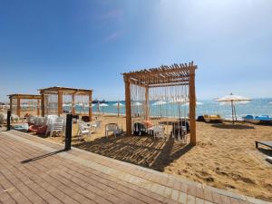 a pavilion on the beach with chairs and an umbrella at Peaceful Challette Two Bedrooms in Murano El Sokhna in Ain Sokhna