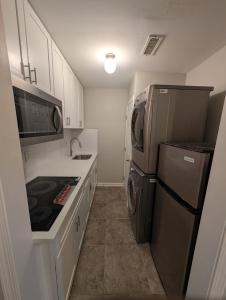 a small kitchen with a refrigerator and a sink at 2 Bedroom Basement Home in Conley