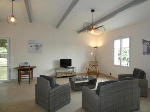 a living room with couches and a table and a tv at Notre Dame de Monts (85) - Maison de vacances 82 m² environ - 6 personnes - FR-1-540-323 in Notre-Dame-de-Monts