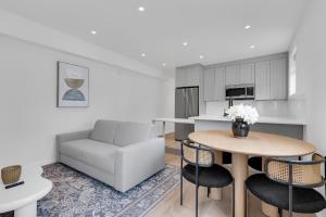 a kitchen and living room with a table and a couch at Le Victoria Midtown Mtl in Montréal +163 photos
