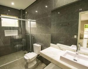 a bathroom with a toilet and a sink and a shower at Aconchego in Paradise Cancun in Águas de Lindóia
