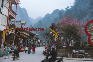 a group of people riding motorcycles down a street at Mountain Sprout Homestay in Dồng Văn
