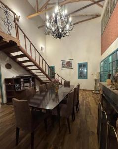a dining room with a table and chairs and a chandelier at Hermosa casa de campo in Tinquipaya