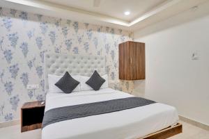 ハイデラバードにあるHotel La Sky Boutique Airport Zone Hyderabadのベッドルーム1室(青い花の壁紙を使用した白いベッド1台付)