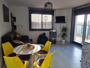 a living room with a table and yellow chairs at Attic terrace 360 Moncofa in Moncófar