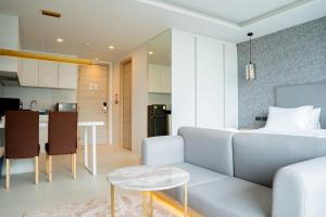 a living room and kitchen with a couch and a table at Utopia Karon in Kata Beach