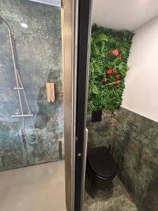 a bathroom with a toilet and flowers on the wall at LA SUITE DES CHARMES - village naturiste - coursives - port nature 2 in Cap d'Agde