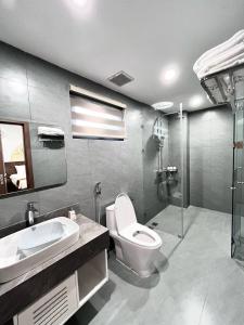 a bathroom with a toilet and a sink and a shower at Cozy Villa V3G08A in Sonasea - Vân Đồn - Gần biển- Đầy đủ tiện nghi in Thâm Câu