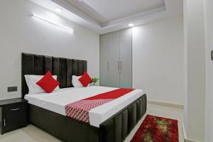 a bedroom with a large bed with red pillows at Hotel O THE CRIMSON PALACE in New Delhi +31 photos