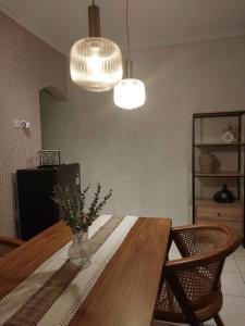 a dining room with a table and two lights at Kenka Homestay in Jetis