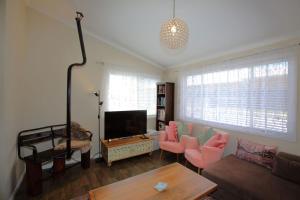 a living room with a couch and a tv at St Helenas 5 Twynam Street in Jindabyne