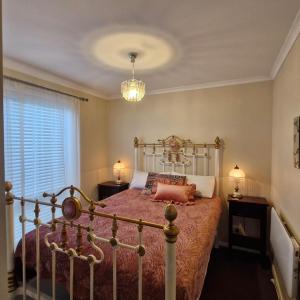 a bedroom with a bed and a chandelier at St Helenas 5 Twynam Street in Jindabyne