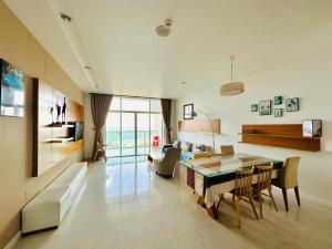 a living room with a table and a dining room at Villa Sealink - Căn Hộ Ocean Vista An in Phan Thiet