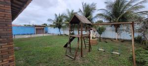 um balanço de madeira em um quintal com palmeiras em Casa de praia em Paracuru mais 3 fotografias