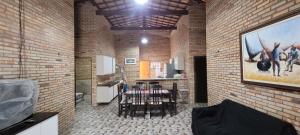 a kitchen and a dining room with a painting on the wall at Casa de praia in Paracuru