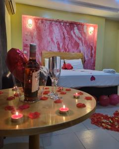 a room with a table with a bottle of wine and candles at Boripe Hotel And Suites in Balogun