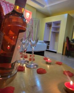 two wine glasses sitting on a table with candles at Boripe Hotel And Suites, Oluponna, Osun State in Olupona