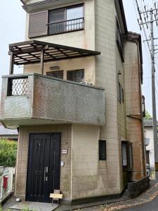 a brick building with a balcony and a door at Guest house 旅人宿ゆるっと in Iburi