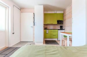 een kleine keuken met groene kasten en een tafel bij Yksiö Turun Hirvensalossa in Turku