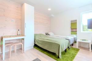 een slaapkamer met twee bedden, een tafel en een bureau bij Yksiö Turun Hirvensalossa in Turku