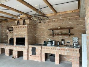 a large kitchen with a brick wall and a counter at Vila Timeea in Statiunea Borsa