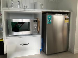 a microwave and a refrigerator in a kitchen at Vineyard Views Rutherglen in Rutherglen