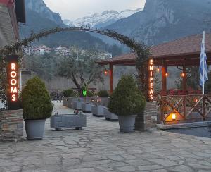 un edificio con cespugli e un cartello con una montagna di Ενοικιαζόμενα Δωμάτια Ενιπεύς- Rooms Enipeas a Litóchoron