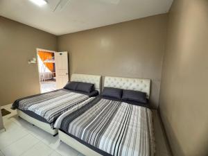 a bedroom with a large bed with blue pillows at Homestay Melaka Executive in Melaka