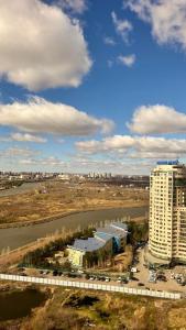 eine Luftaufnahme eines großen Gebäudes und eines Flusses in der Unterkunft Просторная квартира у Набережной в ЖК Симфония in Astana