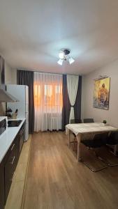 eine Küche mit einem Tisch in der Mitte eines Zimmers in der Unterkunft Просторная квартира у Набережной в ЖК Симфония in Astana