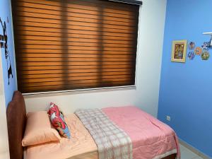 una camera con letto e finestra con persiane di The Makciks Homestay Adelia2 a Kajang
