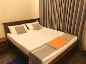 a bed in a small room with a window at UDF City Hotel in Kandy