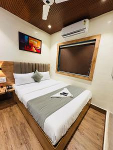 ムンバイにあるHotel Airport By TMAのベッドルーム1室(大型ベッド1台、大画面スクリーン付) +7枚の写真