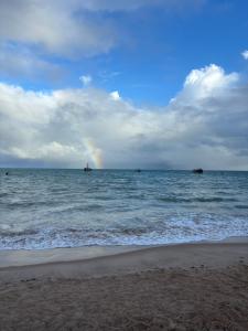 a rainbow in the ocean with ships in the water at Tambaú Israel Flat 217 - Beira mar in João Pessoa