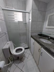 a white bathroom with a toilet and a sink at Boa Viagem Hostel Pequeno Príncipe in Recife