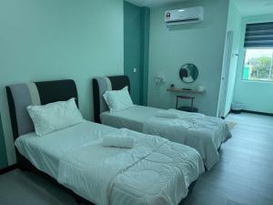 two beds in a room with blue walls at Good Night BD Motel in Bagan Datuk