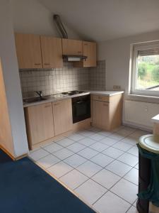 an empty kitchen with wooden cabinets and a window at Herbrechtingen Eselsburg in Herbrechtingen +6 photos