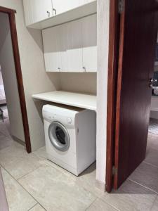 a washer and dryer sitting in a room at Seepraal luxury accommodation in Jeffreys Bay