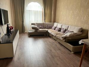 a living room with a large couch in a room at Sumqayit Kristal3 in Sumqayıt +1 photo
