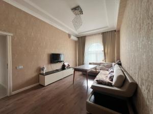 a living room with a couch and a table at Sumqayit Kristal3 in Sumqayıt