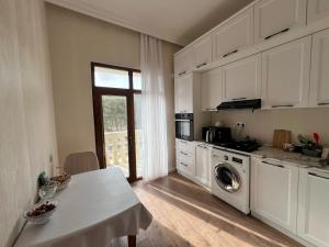a kitchen with a table and a washing machine at Sumqayit Kristal3 in Sumqayıt