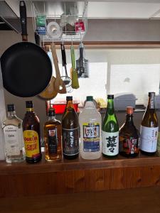a bunch of bottles of alcohol on a shelf at Guest house 旅人宿ゆるっと in Iburi