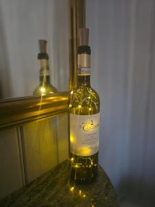a bottle of wine sitting on a table with lights at Siaröfortet in Norra Ljustero