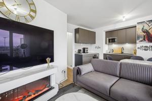 a living room with a couch and a large clock above a fireplace at Le Havre de Paix in Bezons +6 photos